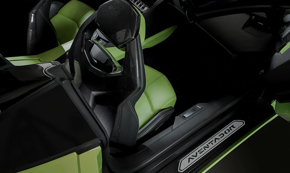 Imagen que muestra un interior oscuro, en piel negra, en la que destaca el asiento en color verde.